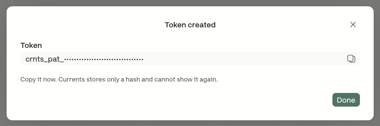 The Token created dialog, showing the crnts_pat_ prefix with the rest of the value obscured for this screenshot, and a warning that Currents stores only a hash and cannot show it again